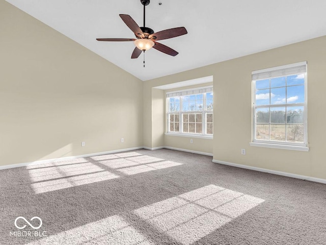 carpeted empty room featuring baseboards, vaulted ceiling, and a ceiling fan