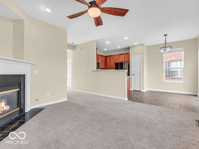 unfurnished living room with dark colored carpet, a fireplace, baseboards, and recessed lighting