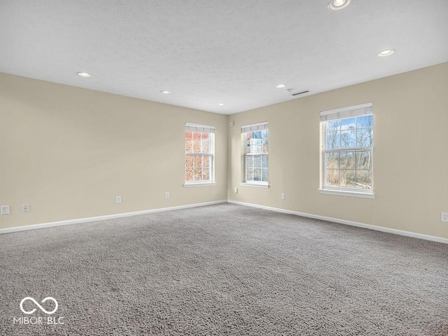 carpeted spare room featuring visible vents, baseboards, and recessed lighting