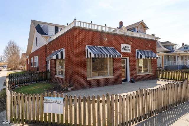 view of front of property with a fenced front yard and brick siding