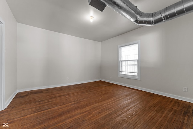 empty room with baseboards and wood-type flooring