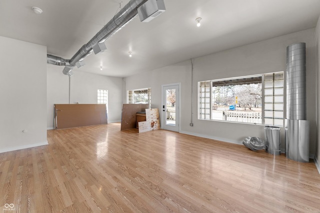 unfurnished living room with baseboards and wood finished floors