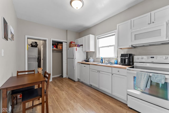 kitchen with white appliances, light wood finished floors, a sink, white cabinets, and wood counters