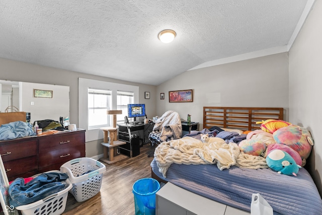 bedroom featuring a textured ceiling, wood finished floors, and vaulted ceiling