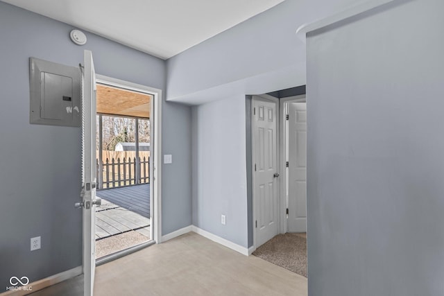 doorway to outside featuring carpet, electric panel, and baseboards