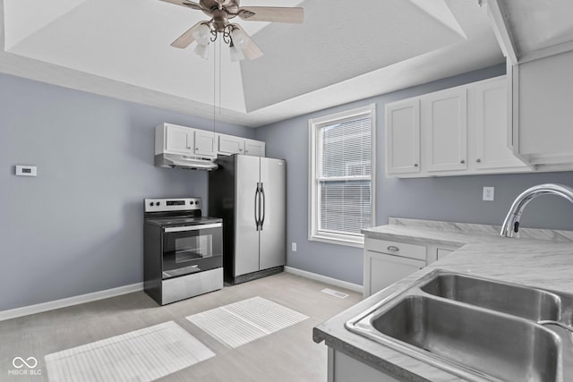 kitchen featuring under cabinet range hood, stainless steel appliances, a sink, white cabinetry, and a raised ceiling