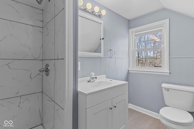 bathroom with a marble finish shower, a wainscoted wall, vanity, and toilet