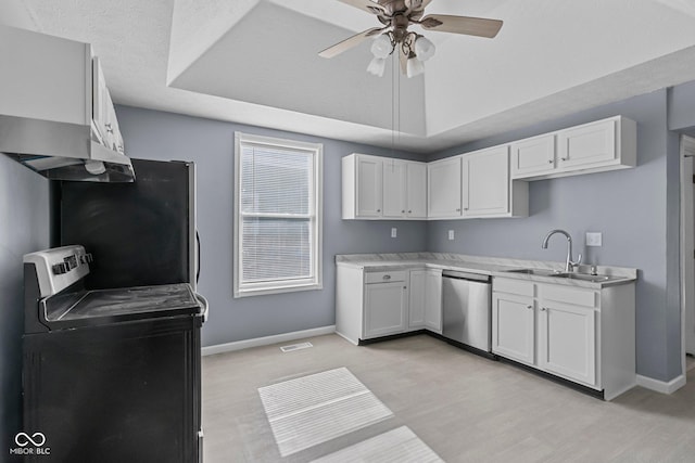 kitchen featuring a sink, white cabinetry, light countertops, appliances with stainless steel finishes, and a raised ceiling