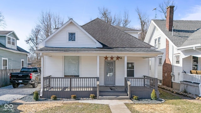 bungalow featuring a porch and roof with shingles