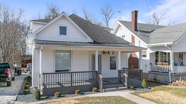 bungalow-style home with covered porch and roof with shingles