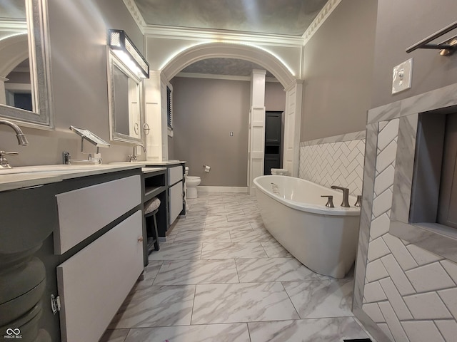 608 E Main St, Crawfordsville, IN 47933 - full bathroom featuring marble finish floor, double vanity, a freestanding bath, toilet, and ornamental molding