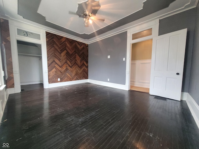 608 E Main St, Crawfordsville, IN 47933 - unfurnished bedroom featuring ceiling fan, an accent wall, wood finished floors, a decorative wall, and a closet