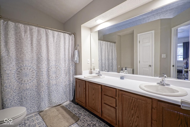 full bathroom with double vanity, toilet, vaulted ceiling, and a sink