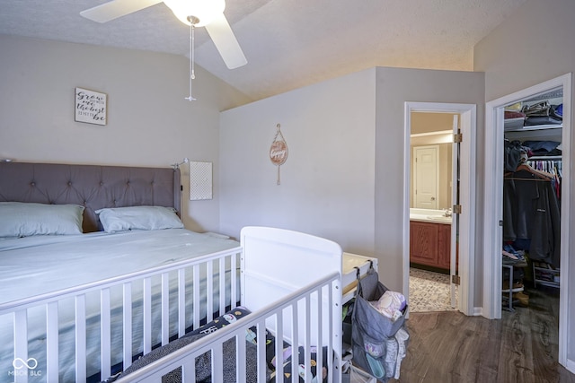 bedroom with connected bathroom, ceiling fan, lofted ceiling, wood finished floors, and a closet