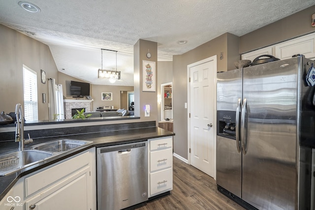 kitchen featuring a sink, dark countertops, white cabinets, and stainless steel appliances