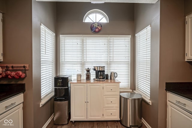 kitchen with dark countertops, white cabinets, and baseboards