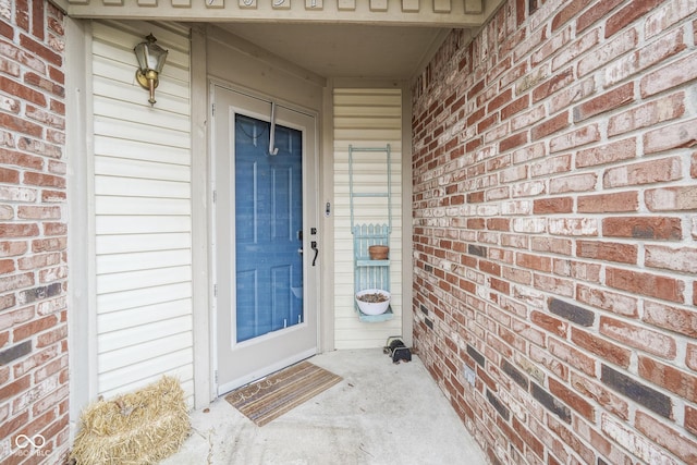 doorway to property with brick siding