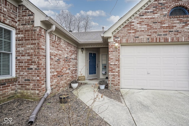 view of exterior entry featuring brick siding, an attached garage, and roof with shingles