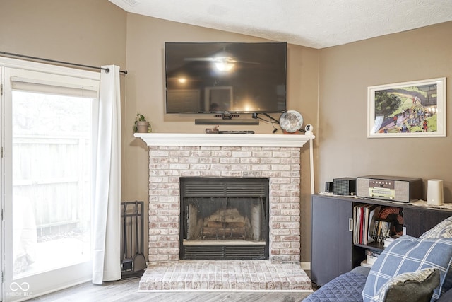 living area featuring wood finished floors, a fireplace, and a textured ceiling