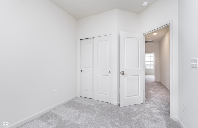 unfurnished bedroom with a closet, carpet flooring, baseboards, and visible vents