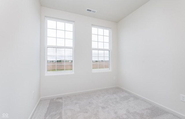 carpeted empty room featuring visible vents and baseboards