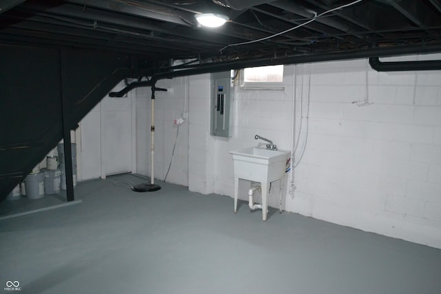 basement featuring electric panel and a sink