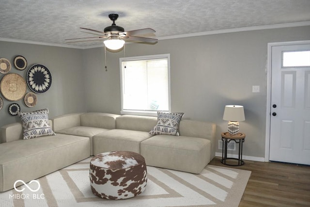 living room with a textured ceiling, ornamental molding, and wood finished floors