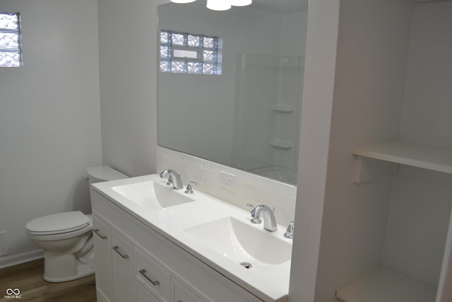 full bathroom featuring wood finished floors, tasteful backsplash, a sink, and toilet