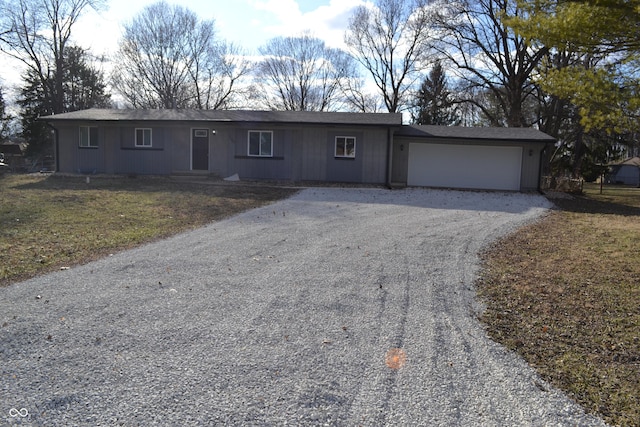 ranch-style house featuring an attached garage and gravel driveway