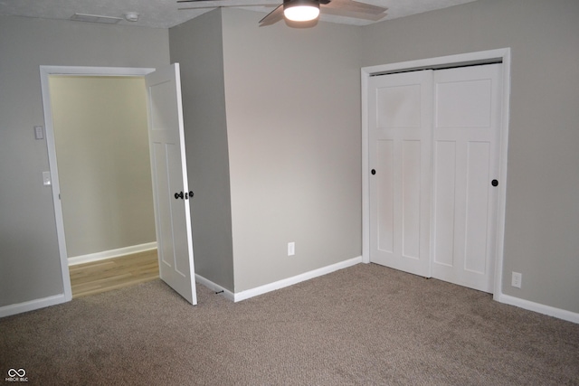 unfurnished bedroom featuring a ceiling fan, carpet, a closet, and baseboards