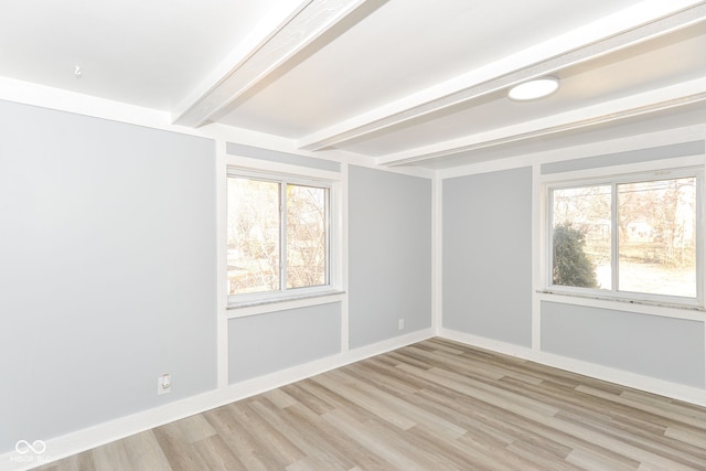 unfurnished room with light wood-type flooring, beam ceiling, a healthy amount of sunlight, and baseboards