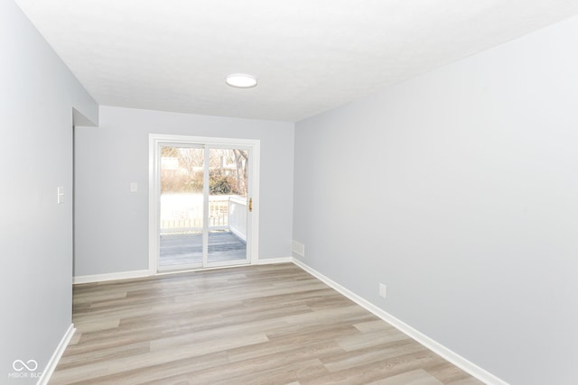 unfurnished room with visible vents, light wood-style flooring, and baseboards