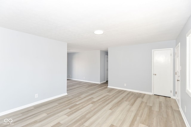 empty room featuring light wood finished floors and baseboards