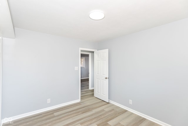 spare room with light wood-type flooring and baseboards