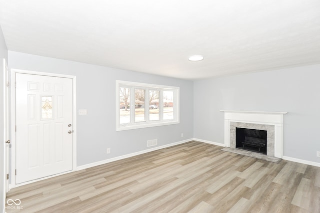 unfurnished living room with light wood-style flooring and baseboards