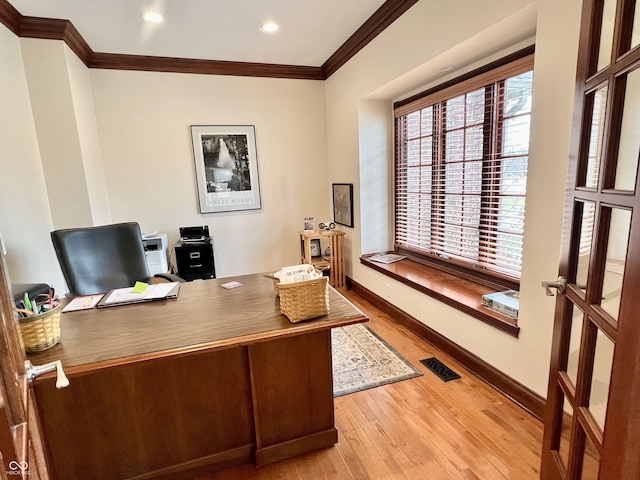 office area featuring light wood finished floors, plenty of natural light, visible vents, and crown molding