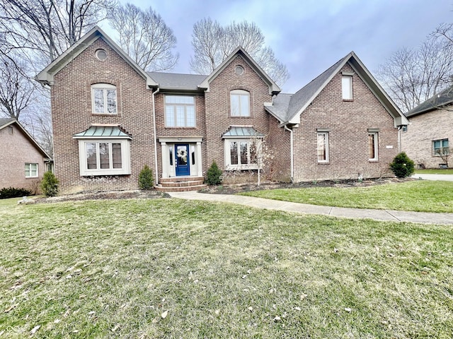 view of front of home featuring a front lawn and brick siding