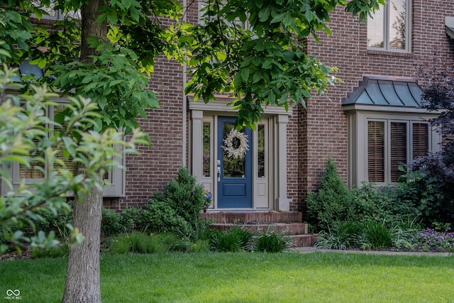 895 Baywood Ct, Columbus, IN 47201 - view of exterior entry featuring brick siding, a lawn, and a standing seam roof