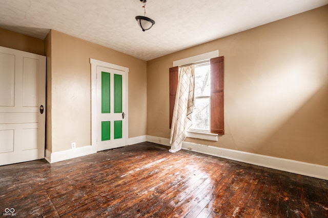 spare room with dark wood-style floors and baseboards