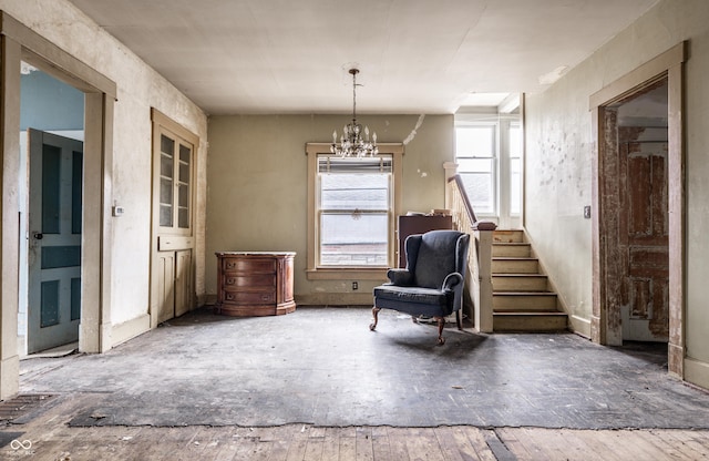 living area with stairs and a notable chandelier