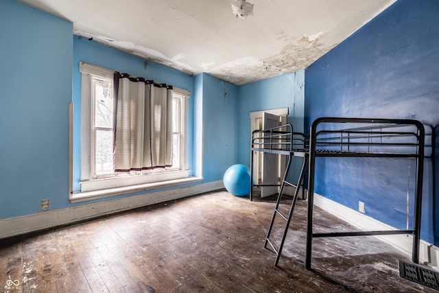 bedroom with hardwood / wood-style floors and baseboards