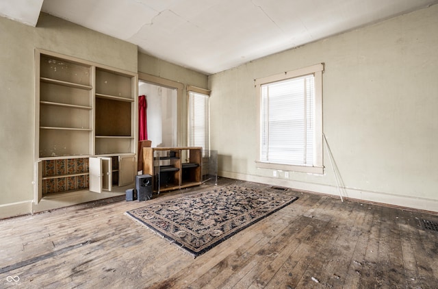 interior space with visible vents, wood-type flooring, and baseboards