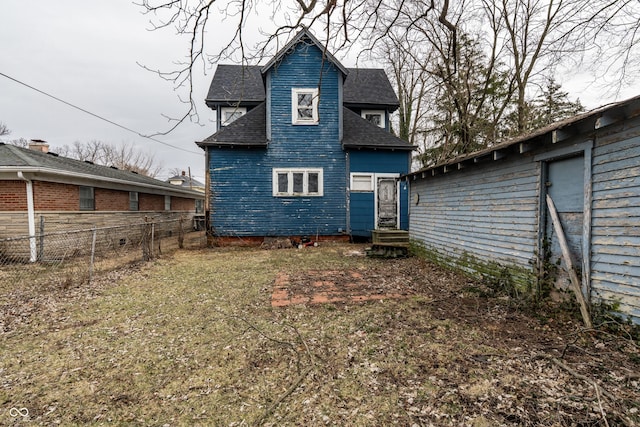 back of property featuring roof with shingles and fence