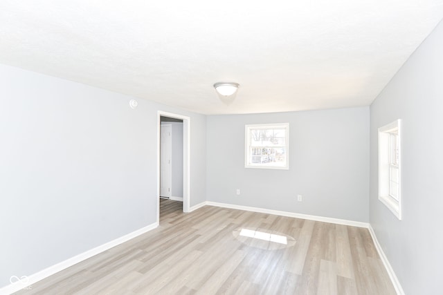 empty room with light wood finished floors and baseboards