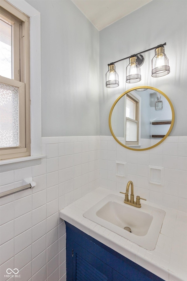 bathroom featuring tile walls, a wainscoted wall, and vanity