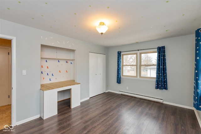 unfurnished bedroom with baseboards, baseboard heating, and dark wood-type flooring