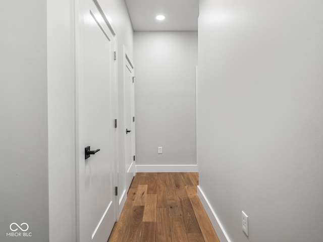 hallway featuring recessed lighting, baseboards, and hardwood / wood-style floors