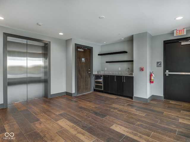 kitchen with light countertops, dark wood-style flooring, recessed lighting, and elevator