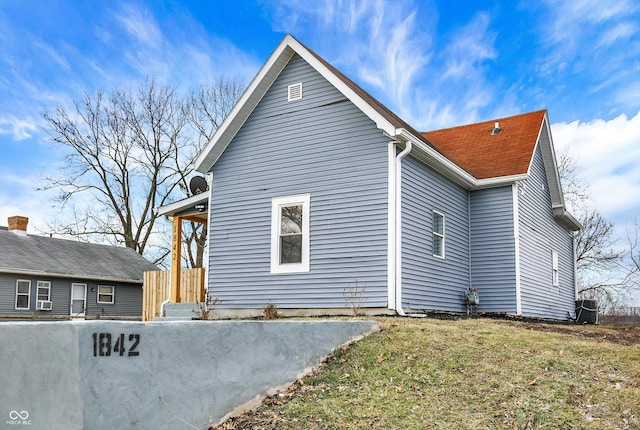 view of side of property with a yard and central AC unit