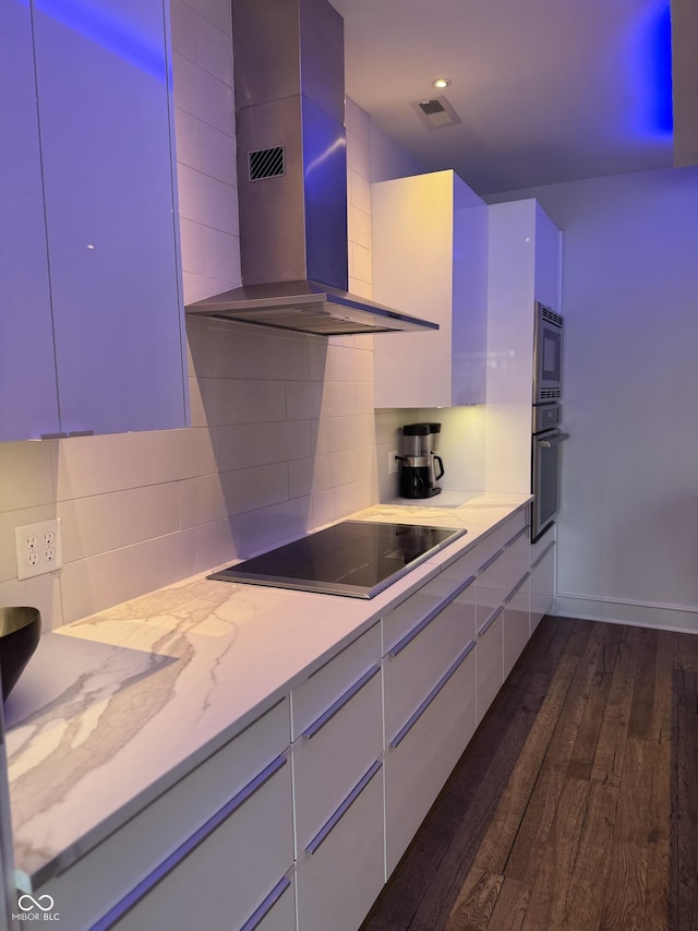 kitchen with visible vents, black appliances, backsplash, dark wood-style floors, and wall chimney exhaust hood